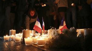 A woman places a candle during a vigil to honor victims of the Bastille Day tragedy in Nice, France, in Sydney, Australia, Friday, July 15, 2016. World leaders are expressing dismay, sadness and solidarity with France over the attack carried out by a man who drove truck into crowds of people celebrating France's national day in Nice. (AP Photo/Rob Griffith)